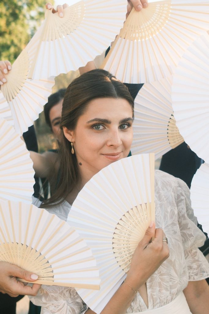 Mariage de Marion et Thomas : portrait de la mariée avec un éventail en dentelle blanche