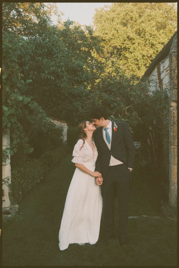 Mariage de Marion et Thomas : les mariés s'embrassent sous les arbres, photo argentique