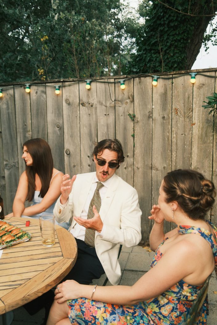 Invités souriants et complices pendant la réception de mariage