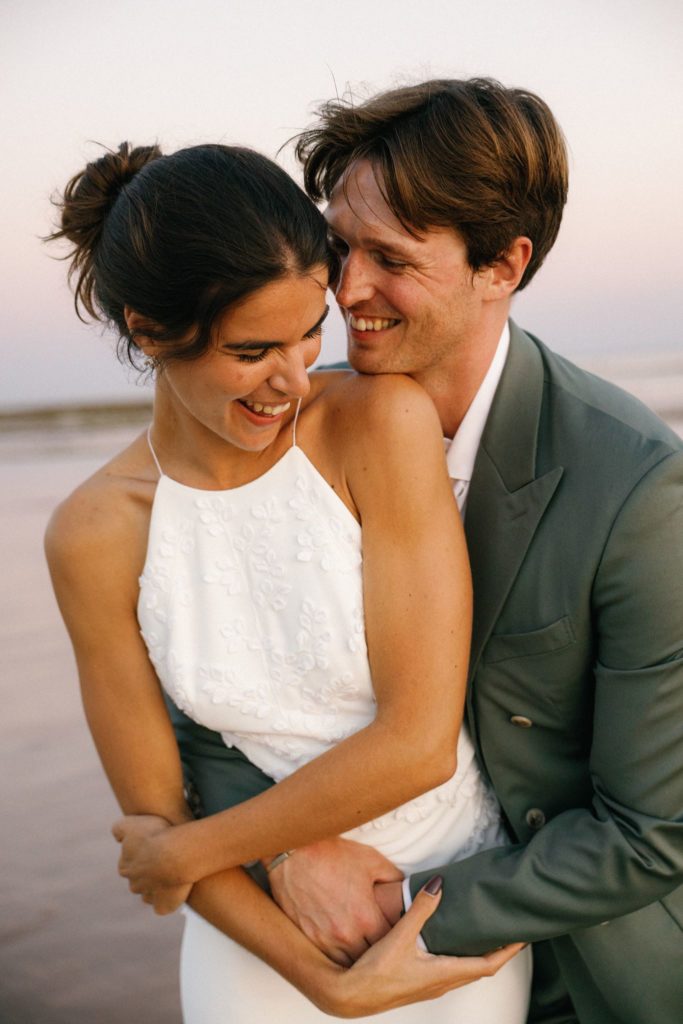 Mariage de Juliette et James : portrait souriant des mariés au coucher du soleil